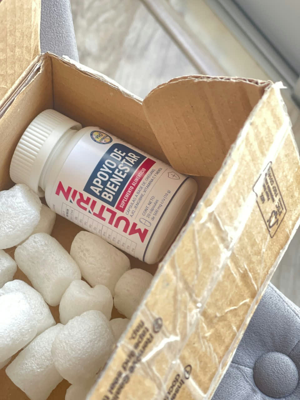 Caja de envío abierta con el frasco de Multirin dentro